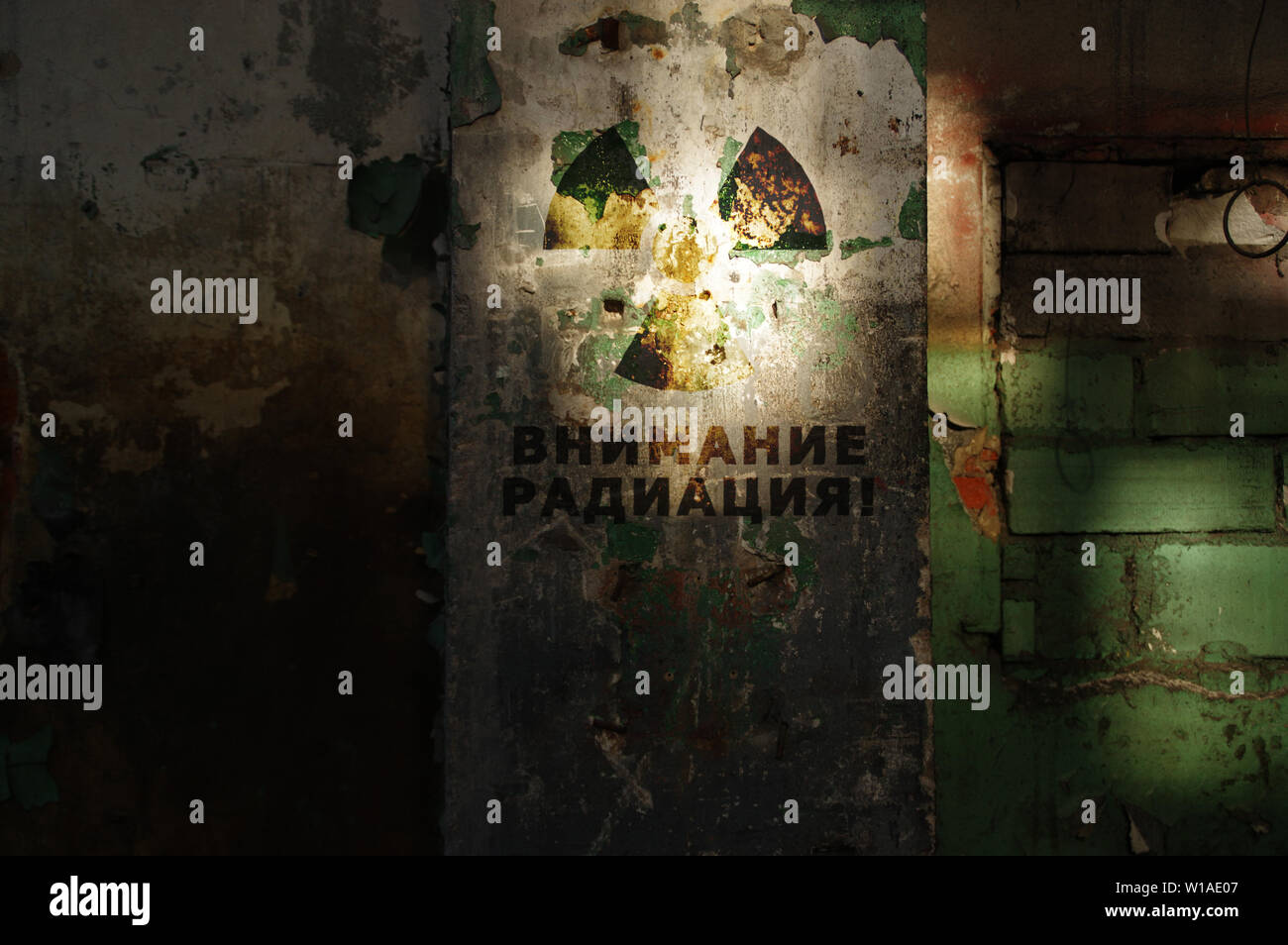 Radioaktive Warnung auf alte beschädigte Wand. Zerstört und vergessen. Strahlung Symbol mit russischen Alert. Nach der nuklearen Katastrophe. Stockfoto