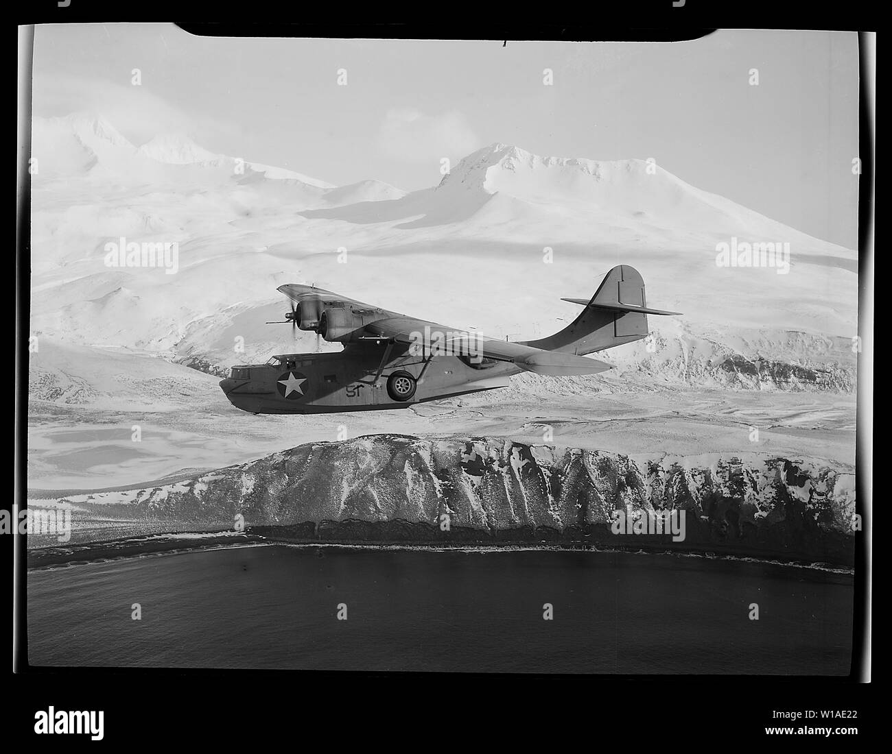 Eine PBY-5A Catalina Patrol bomber Kreuzfahrten Vor dem Hintergrund der schneebedeckten Berge in Aleutian Inseln, auf der Suche nach feindliche Aktivitäten.; Allgemeine Hinweise: Englisch: U.S. Navy Consolidated PBY-5A Catalina von Patrol squadron VP-61 über Alaska (USA), März 1943. Stockfoto