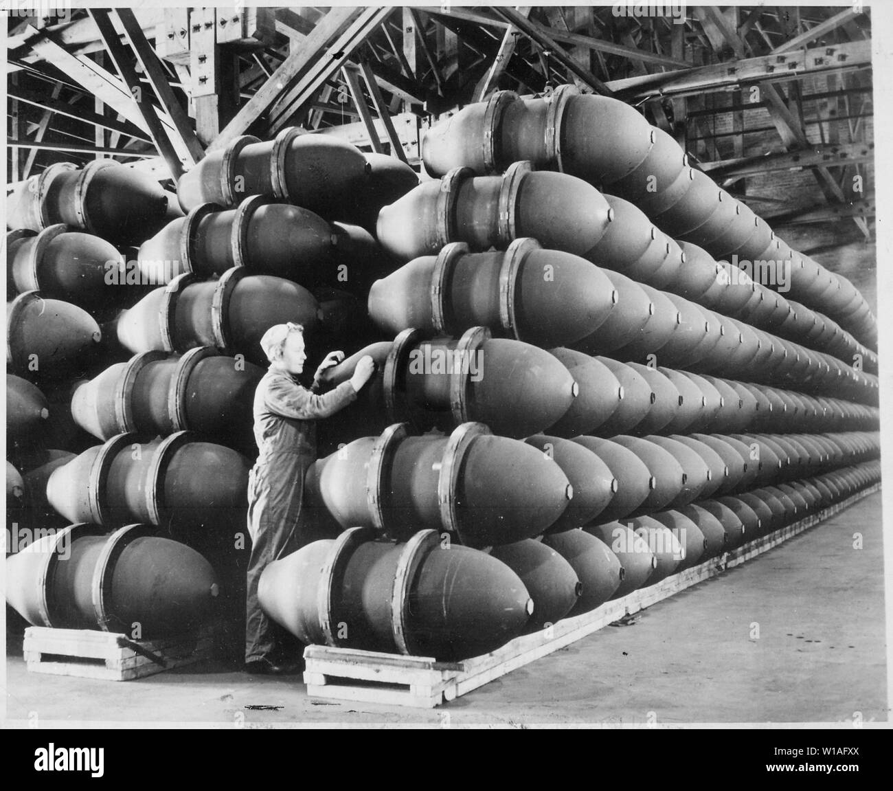 Eine Frau Krieg Arbeiter Schecks über 1.000 Pfund Bombe Fällen, bevor Sie  sind mit tödlichen Gebühren mit Sprengstoff gefüllt und versandt, um  Alliierte Stützpunkte und Fronten auf der ganzen Welt. Firestone Reifen