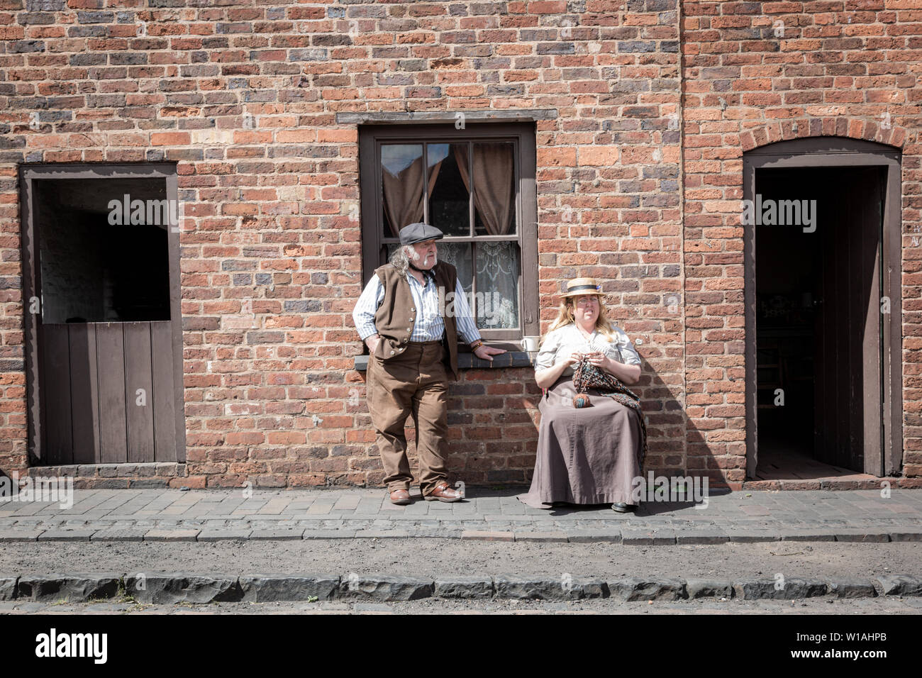 Zwei Personen im Edwardianischen Kleidung außerhalb ein Reihenhaus gekleidet, Black Country Living Museum, Dudley GROSSBRITANNIEN Stockfoto