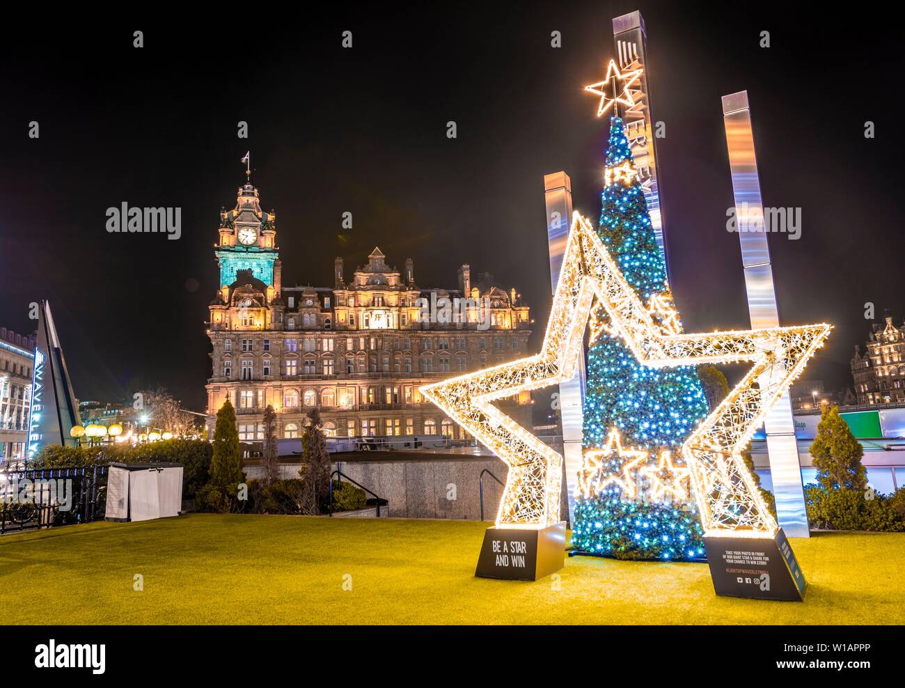 Eine europäische Starling und Gewinnen, Weihnachten Dekoration vor der Balmoral Hotel, historische Altstadt bei Nacht, Edinburgh, Schottland, Vereinigtes Königreich Stockfoto