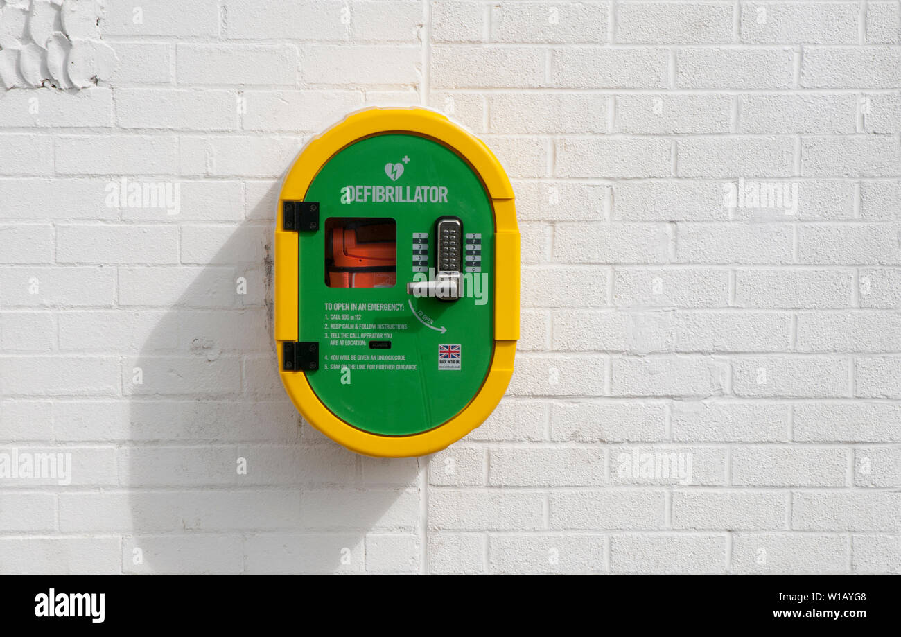 Lebensrettenden Defibrillator Ausrüstung auf Wand von Gebäude im Sport Bereich der lokalen Park Blackpool Lancashire England Großbritannien positioniert Stockfoto