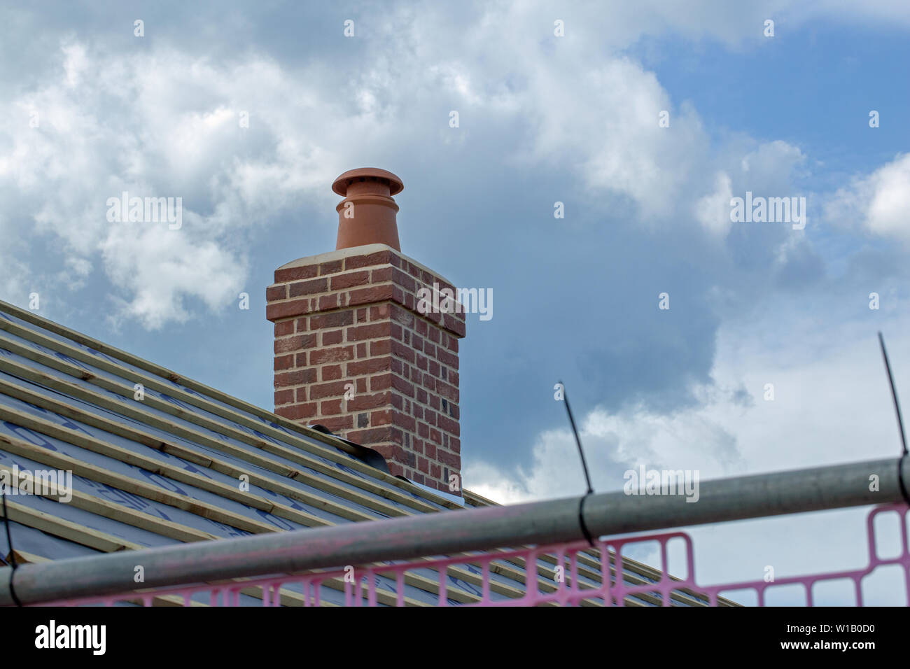 ​Chimney Topf, Schornstein oben ein neues Dach auf einem Re-build, redundante Bauernhaus, Umbau. Lange und kurze Mauerwerk. Fliesen immer noch auf dem Dach platziert werden. Stockfoto