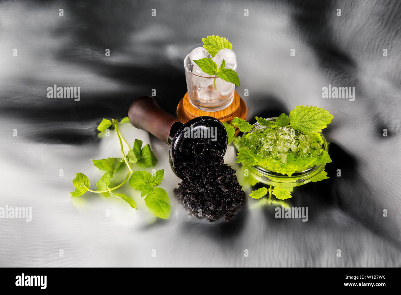 Shisha Schüssel mit Tabak im Rauch und Glas Schale mit Minze und Eis. Eis Minze shisha Tabak. Stockfoto