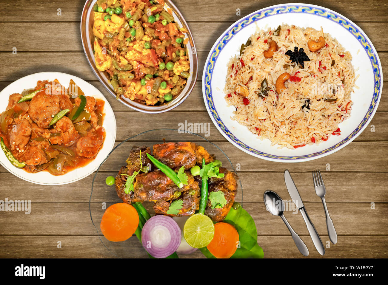 Leckeres indisches Essen Mahlzeit von gebratener Reis mit gemischtem Gemüse zusammen mit Red Hot scharf gewürzten Hummer Teller garniert mit Salat und würzig Chili Huhn Stockfoto