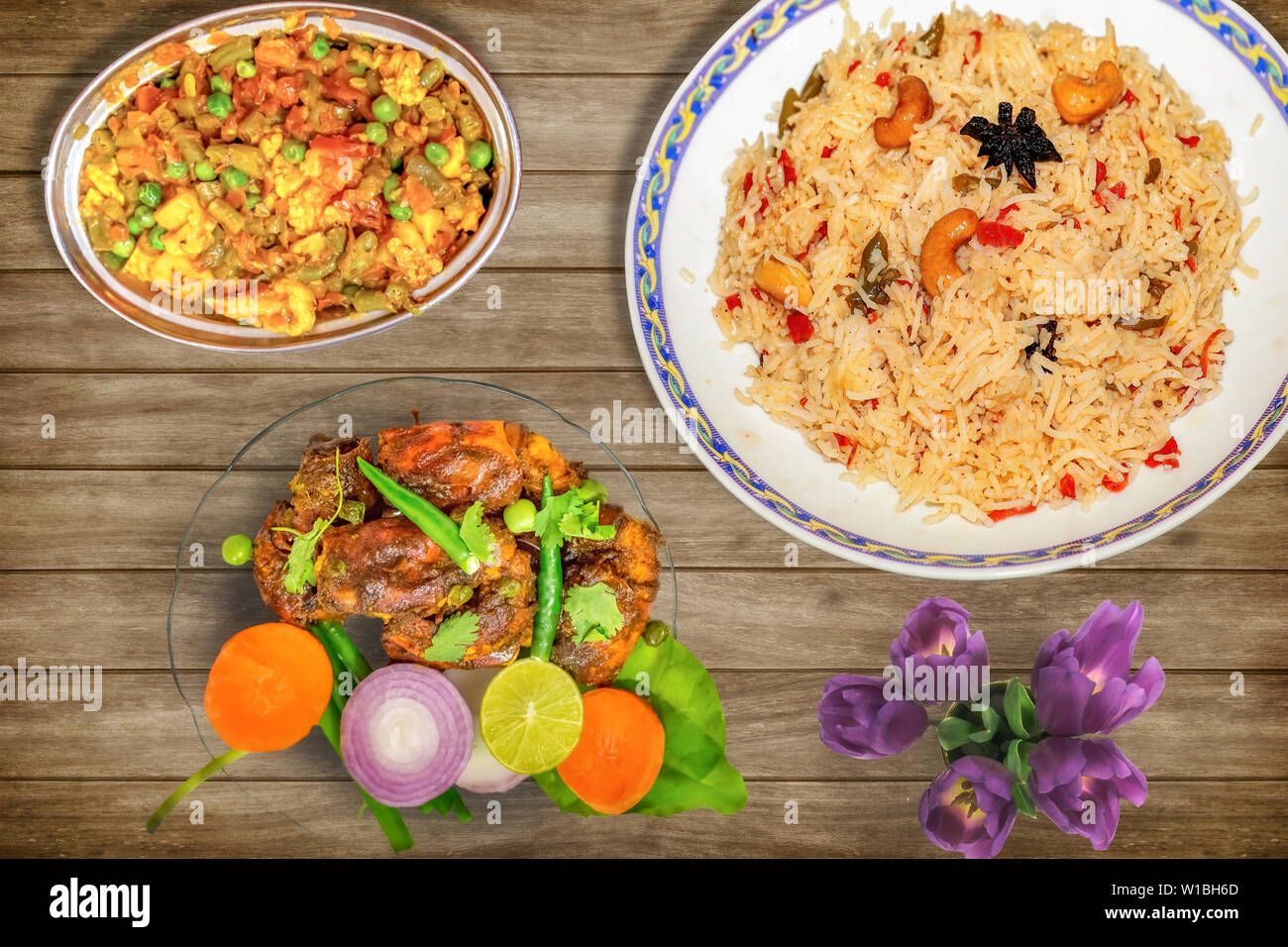 Leckeres indisches Essen Mahlzeit von gebratener Reis mit gemischtem Gemüse zusammen mit Red Hot scharf gewürzten Hummer Teller garniert mit Salat und würzig Chili Huhn Stockfoto