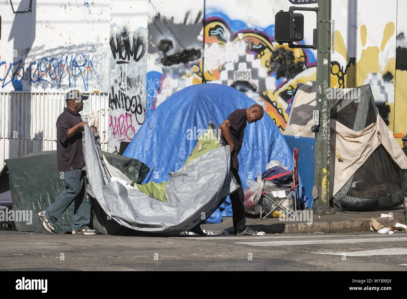 Los Angeles, Kalifornien, USA. 1. Juli 2019. Obdachlose Menschen bewegen, Sachen von einer Straße als die Stadt Crews bereit, die Innenstadt von Civic Center Bereich in den Montag zu reinigen, 1. Juli 2019. Los Angeles Bürgermeister Eric Garcetti und eine Gruppe anderer Stadtführer, um von Kalifornien und der Nation sichern die geplante Beendigung der Obdachlosigkeit handeln. Die Rechtsvorschriften von US-Rep. Maxine Waters, D-Calif. gesponsert wird, würden sie mehr als $ 13 Mrd. auf die Bemühungen der Städte mit der obdachlosigkeit Krise zu bewältigen. Credit: Ringo Chiu/ZUMA Draht/Alamy leben Nachrichten Stockfoto