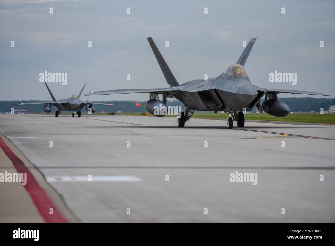 F-22 Raptors aus dem 1 Fighter Wing, 27 Fighter Squadron Taxis für die Abreise während einer Bereitstellung zu Al Udeid Air Base, Katar, von der gemeinsamen Basis Langley-Eustis, Virginia. Der F-22 in Katar zum ersten Mal um Amerikanische Kräfte und Interessen in der US Central Command Verantwortungsbereich verteidigen eingesetzt. (U.S. Air Force Foto von Airman First Class Monica Roybal) Stockfoto