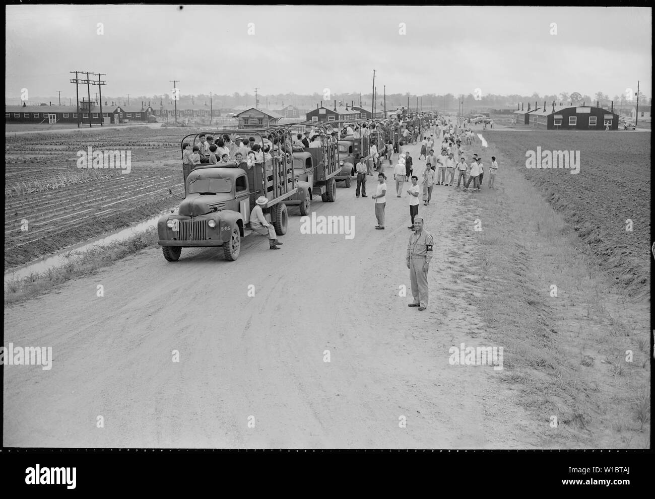 Schließen der Jerome Relocation Center, Denson, Arkansas. Einer der 500 Jerome Bewohner, warten. . .; Umfang und Inhalt: Der vollständige Titel für dieses Foto lautet: Schließen der Jerome Relocation Center, Denson, Arkansas. Einer der 500 Jerome Bewohner, warten auf den Zug für eine Bewegung nach Granada Center gestellt werden, Gebote auf Wiedersehen zu einem Nachbarn, deren neue Residenz wird die Rohwer Center. Stockfoto