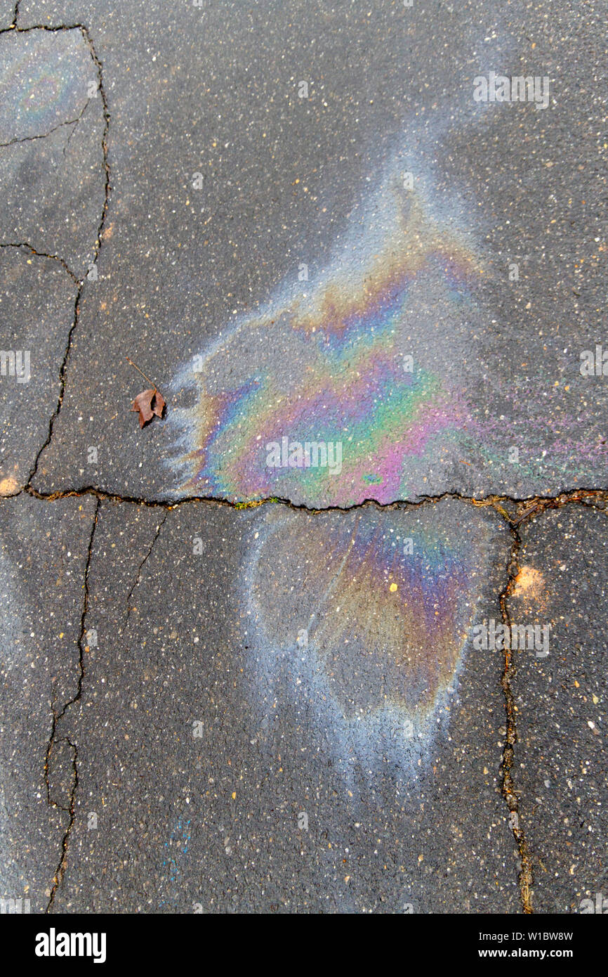 Nahaufnahme eines bunten, giftiger Ölteppich auf Risse im Asphalt der Straße verschüttet Stockfoto
