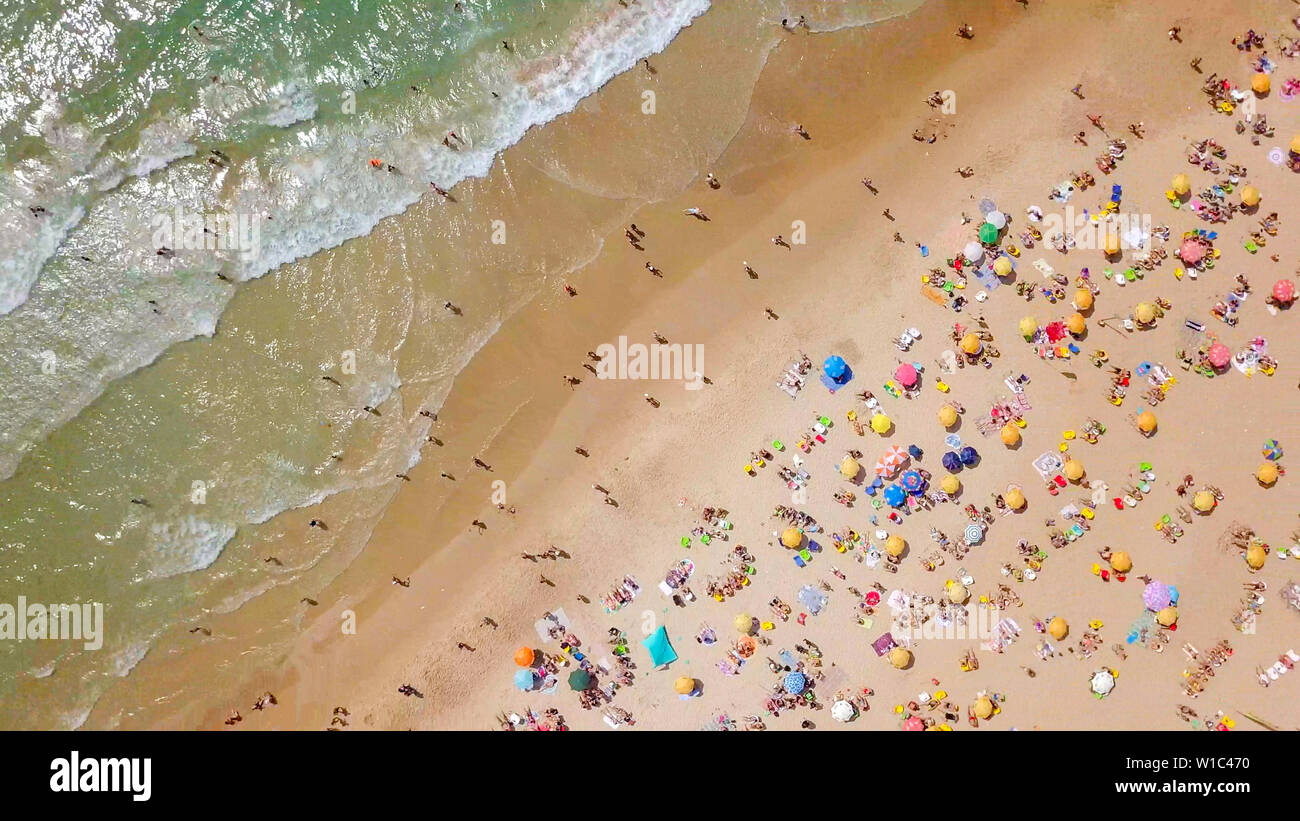 Überfüllten, öffentlichen Strand mit bunten Sonnenschirmen, Luftbild. Stockfoto