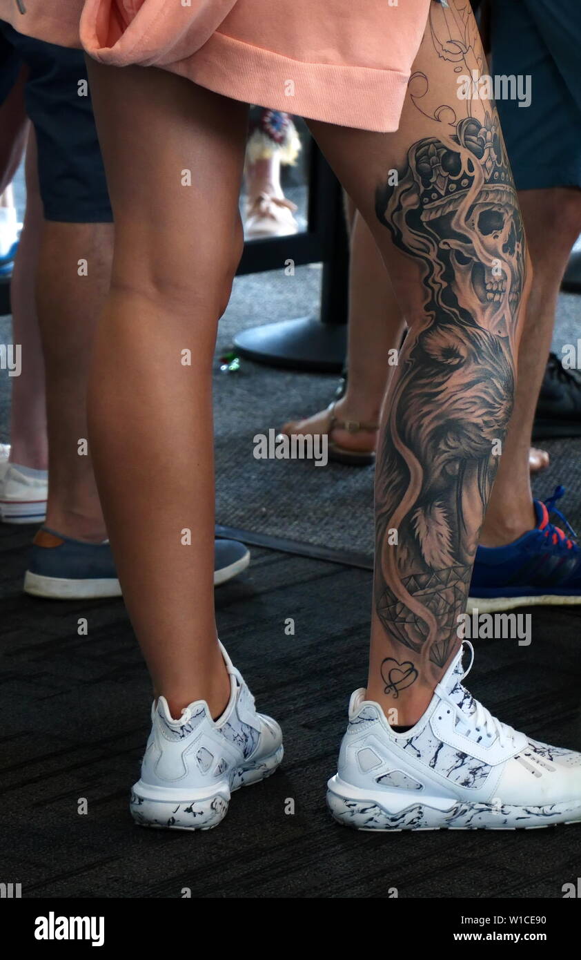 Chicago, IL, USA. Aug 2018. Einzigartige Tattoo Kunst auf diese schön geformten und gebräunte Beine. Stockfoto