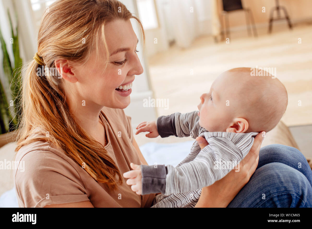 Fröhliche Mutter mit Kleinkind zu Hause Stockfoto