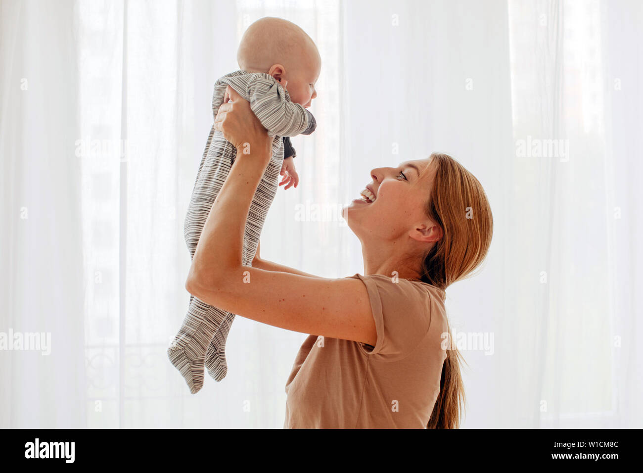 Glückliche Familie Mutter spielt mit neugeborenen Babys Stockfoto