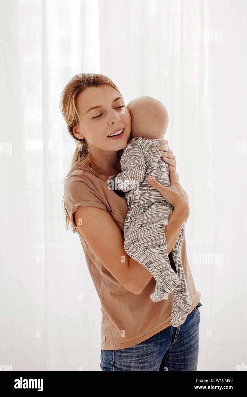 Mutter umarmt baby Stockfoto