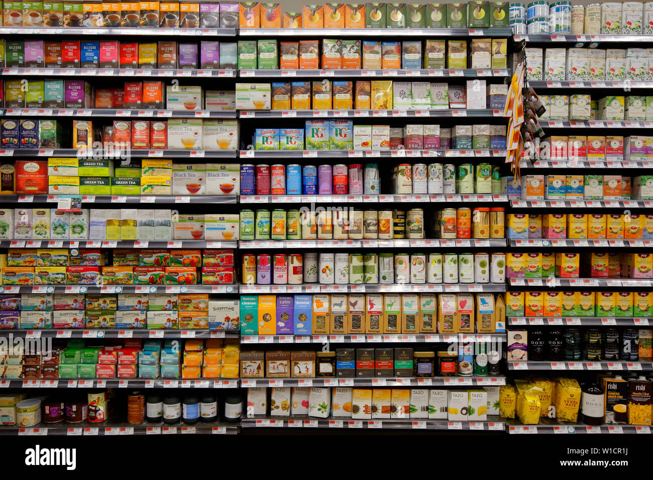 Verschiedene Marken und Sorten von Tee, Kräutertees in einem gut sortierten Supermarkt, ein Paradox der Wahl für den Verbraucher. Stockfoto