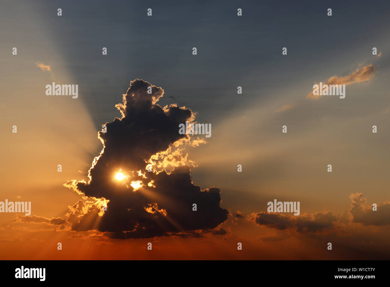 Sonnenuntergang auf bunte Himmel, die Sonne scheint durch die dunklen Wolken. Malerische Landschaft am Abend für Hintergrund Stockfoto