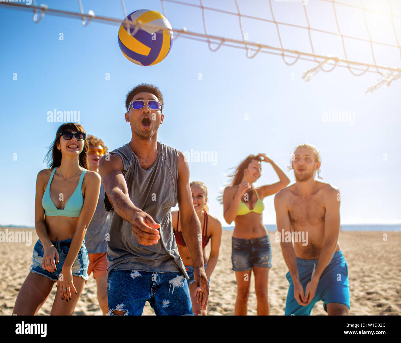 Gruppe von Freunden zu Beach-Volleyball am Strand spielen Stockfoto