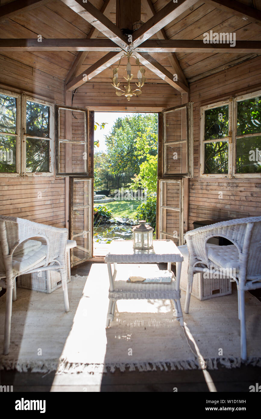 Sommer Hütte in einem Garten mit weißen Stühlen, urlaub Konzept Stockfoto