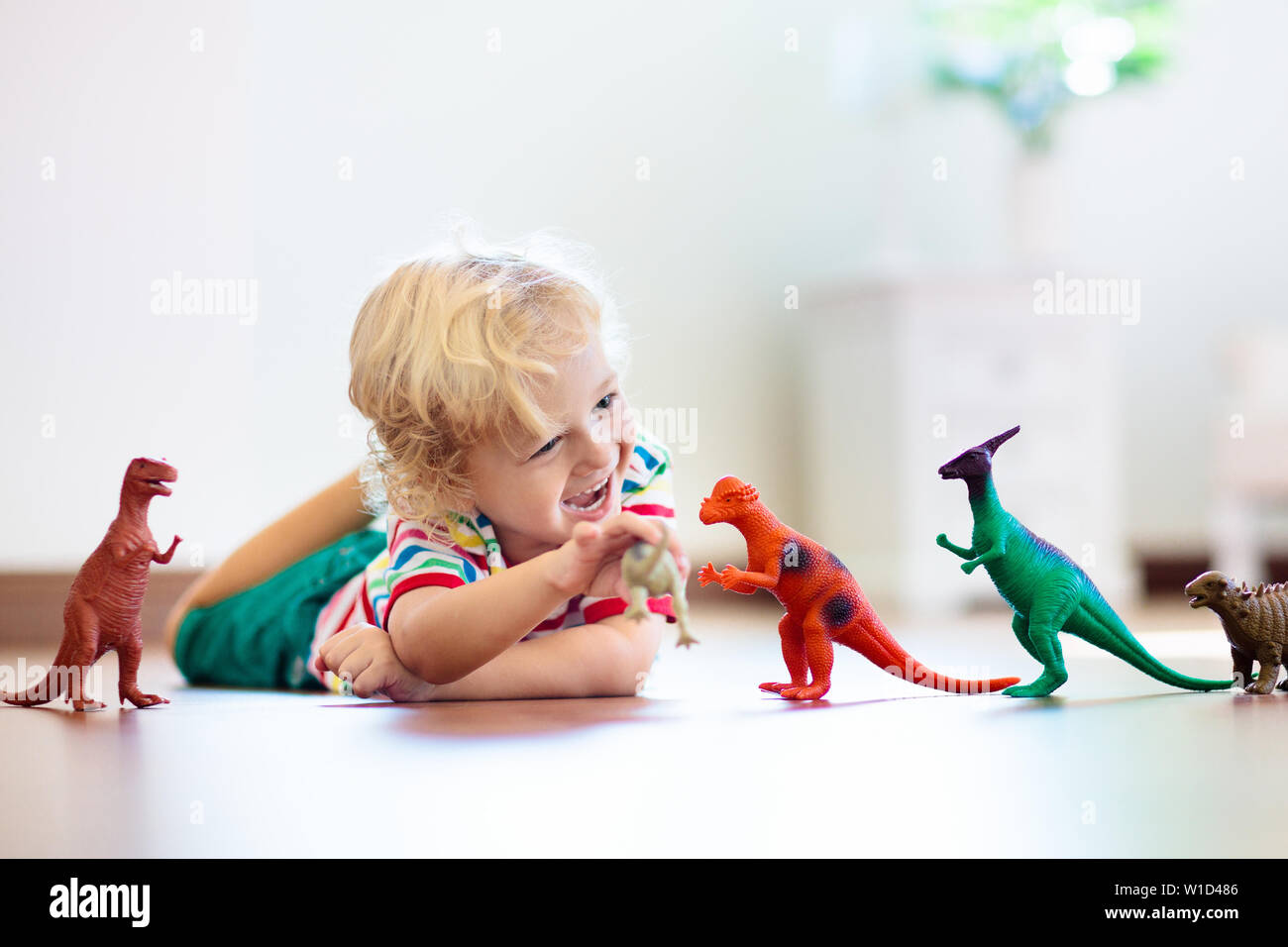 Kinder spielen mit bunten Spielzeug Dinosaurier. Pädagogische Spielwaren für Kinder. Kleinen Jungen lernen, Fossilien und Reptilien. Kinder spielen mit Dinosaurier Spielzeug. Evol Stockfoto