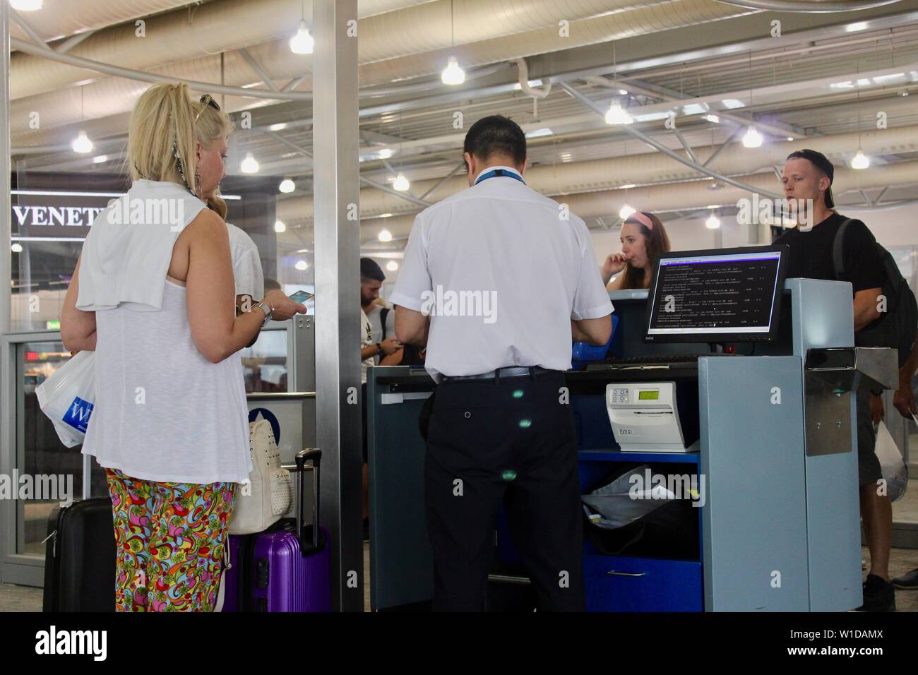Ryanair Passagiere zahlen über Gebühren für die übergroßen Taschen usw. am Flughafen Athen Griechenland Stockfoto