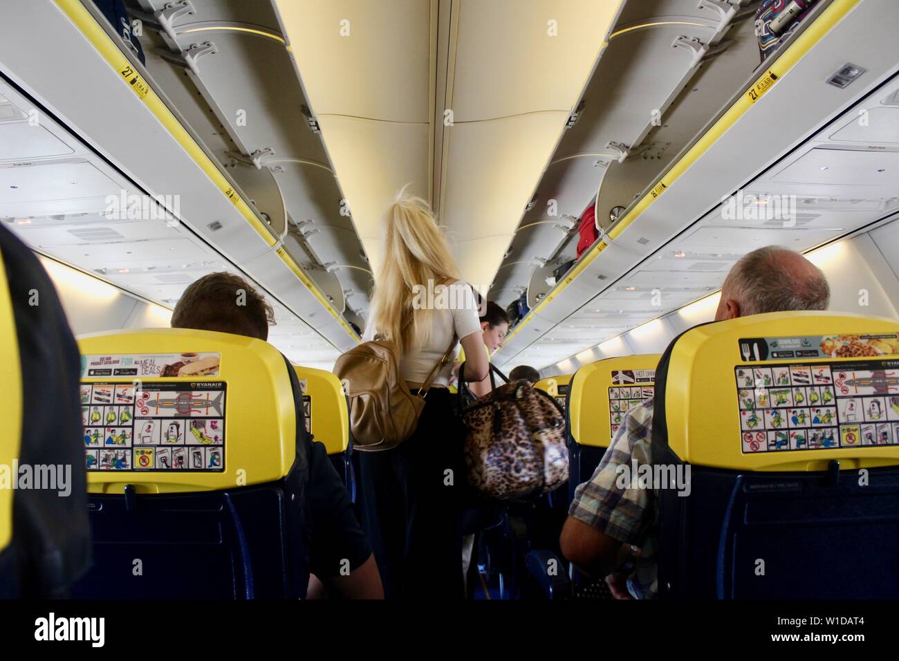 Eine blonde Frau Fahrgast mit Taschen auf Ryanair Flug Stockfoto