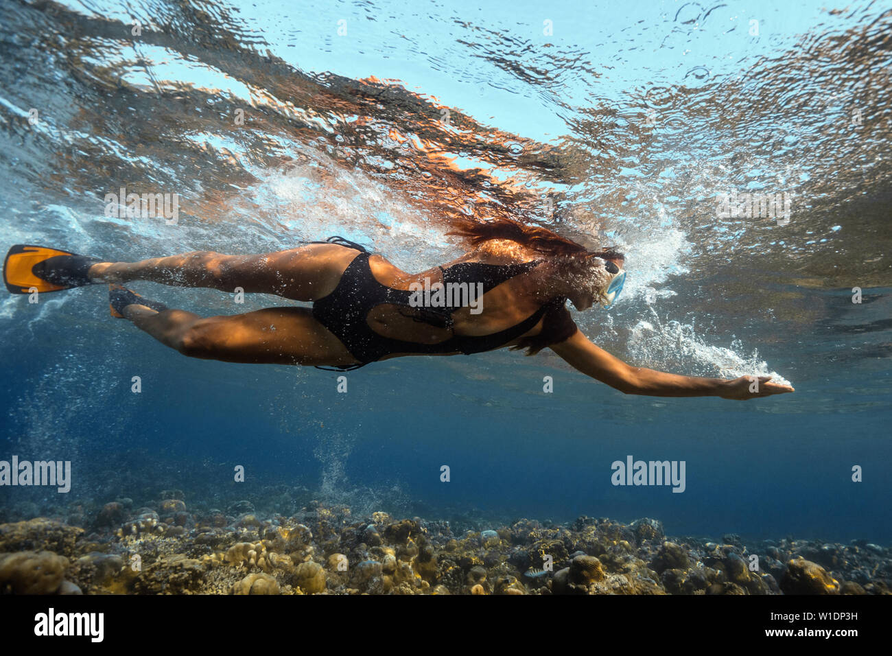 Attraktive junge Frau floating in wunderschönen Ozean Stockfoto