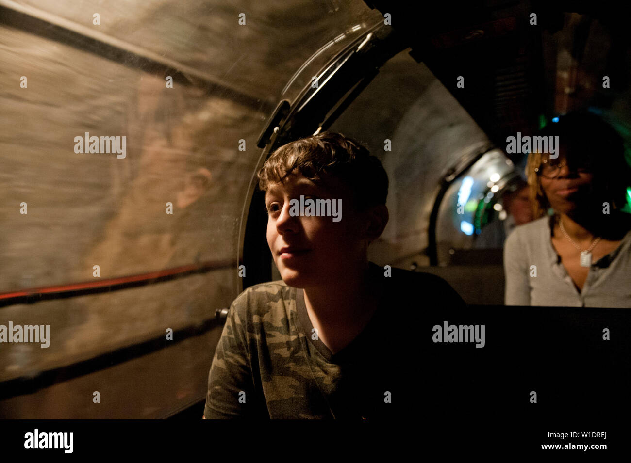 Teenager reiten auf dem Mail Rail Zug am Postal Museum, London, Stockfoto