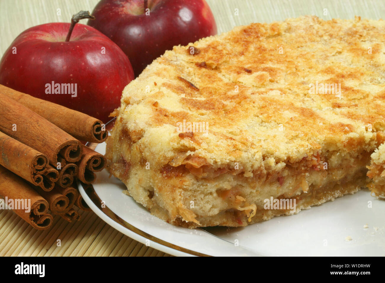 Frisch gebackenen Apfelkuchen mit roten Äpfeln und ganze Zimtstangen. Köstliches Dessert Stockfoto