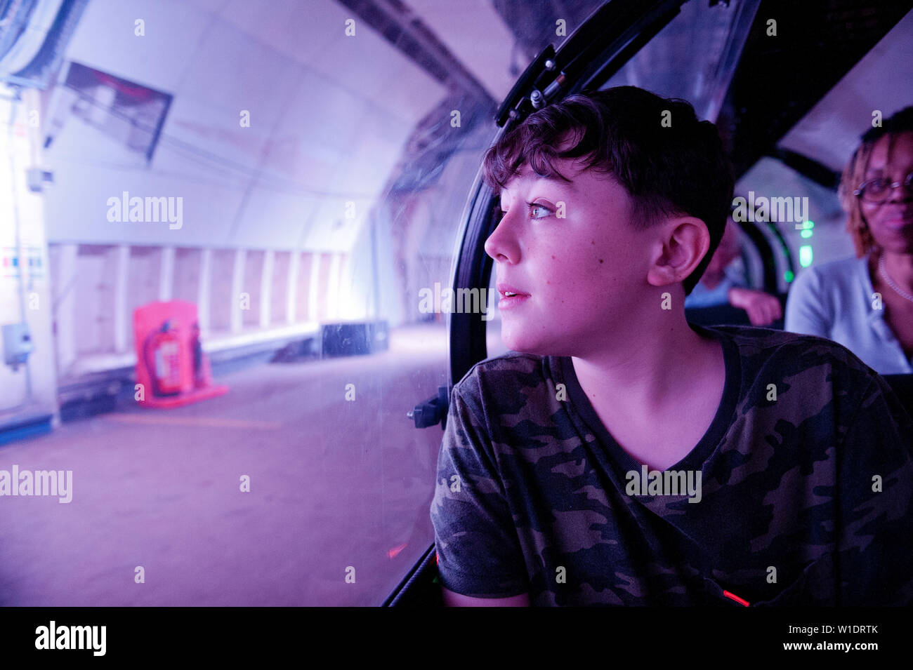 Teenager reiten auf dem Mail Rail Zug am Postal Museum, London, Stockfoto