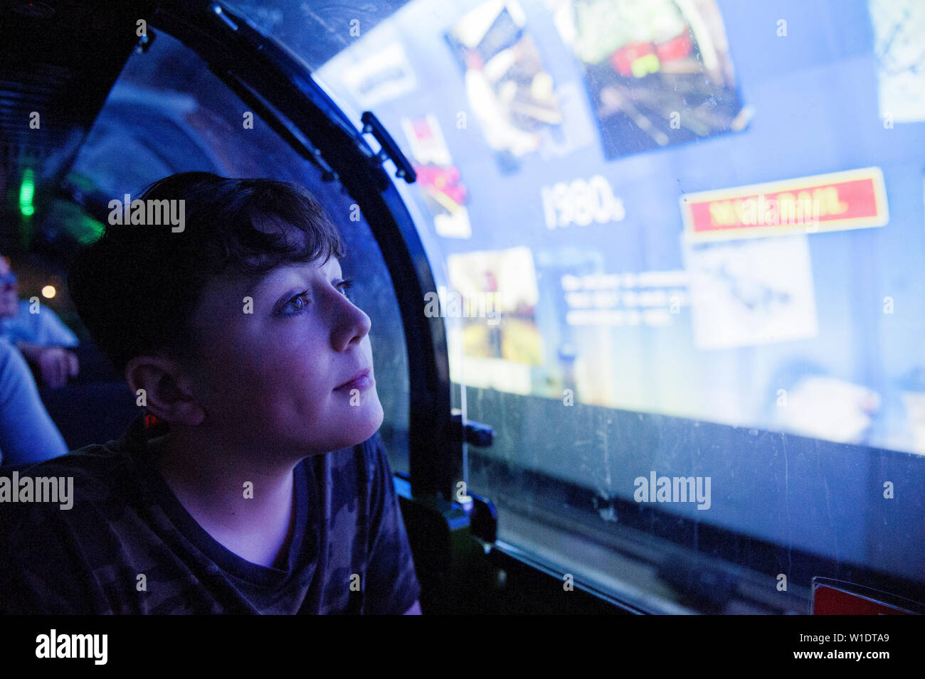 Teenager reiten auf dem Mail Rail Zug am Postal Museum, London, Stockfoto