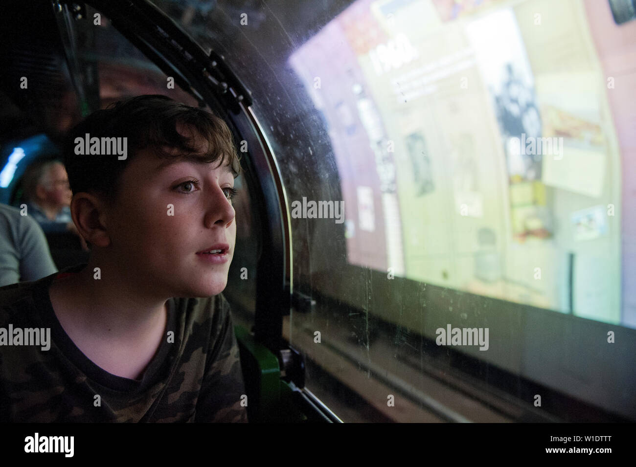Teenager reiten auf dem Mail Rail Zug am Postal Museum, London, Stockfoto