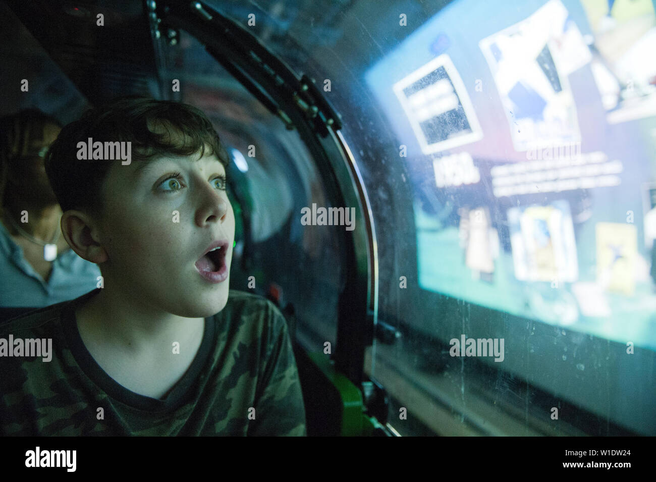 Teenager reiten auf dem Mail Rail Zug am Postal Museum, London, Stockfoto