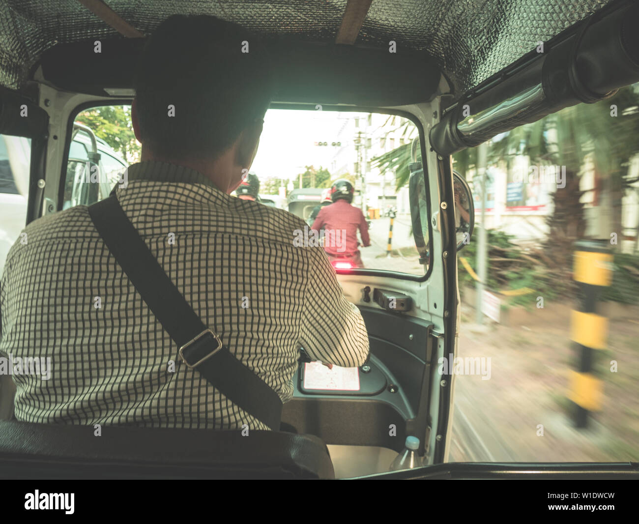 POV unkenntlich Mann, ein Tuk Tuk in Kambodscha. Günstige Verkehrsmittel in Südostasien. Suburst Hintergrundbeleuchtung. Stockfoto