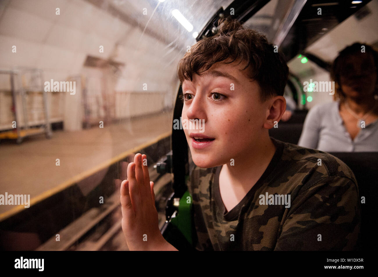 Teenager reiten auf dem Mail Rail Zug am Postal Museum, London, Stockfoto