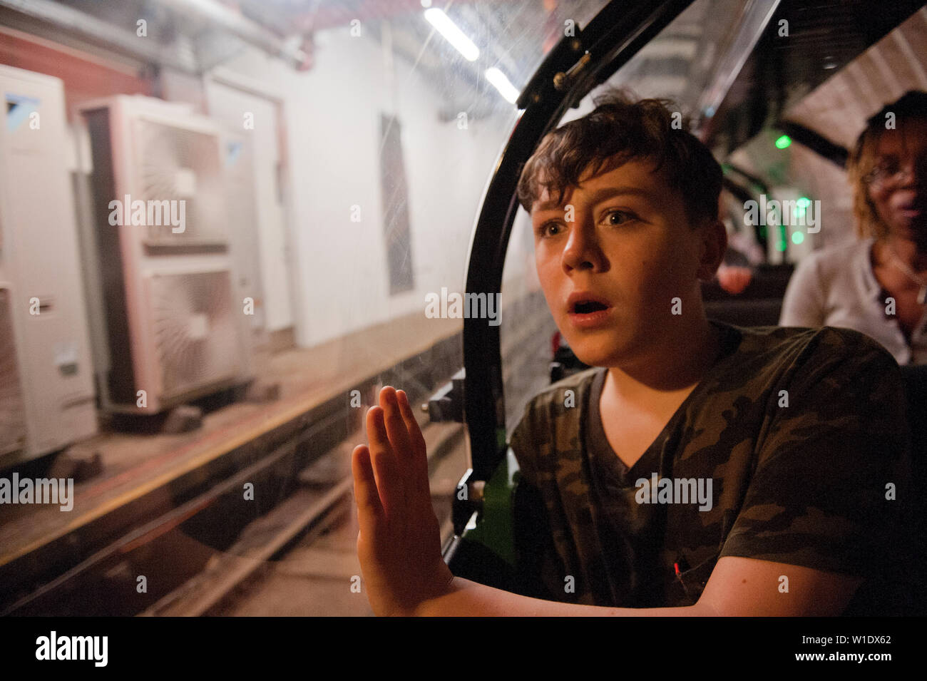 Teenager reiten auf dem Mail Rail Zug am Postal Museum, London, Stockfoto