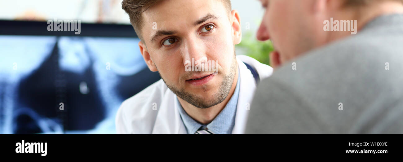 Stattliche männliche Arzt Beratung Patienten zeigen etwas an Tablet PC-Anzeige Stockfoto