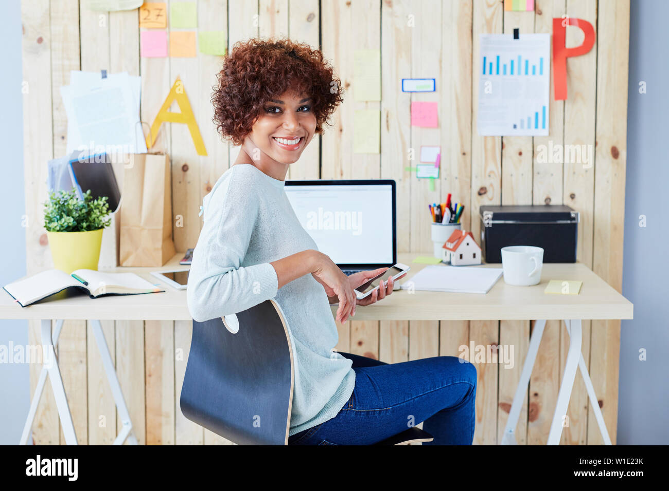 Glückliche Schüler vom Schreibtisch zu Hause sitzen Stockfoto