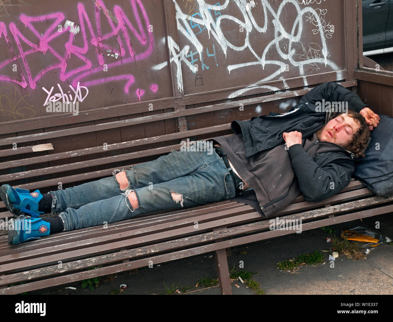 Schlafend auf einer Bank in einem Brighton Street Stockfoto
