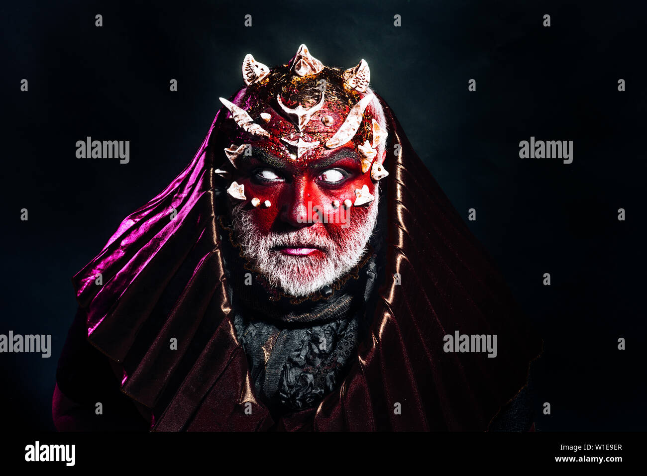 Dämon mit Dornen auf rote Haut tragen metallische Haube. Bärtiger Mann im  Halloween Kostüm. Teufel mit blinden Augen auf schwarzem Hintergrund, Hölle  und Te isoliert Stockfotografie - Alamy