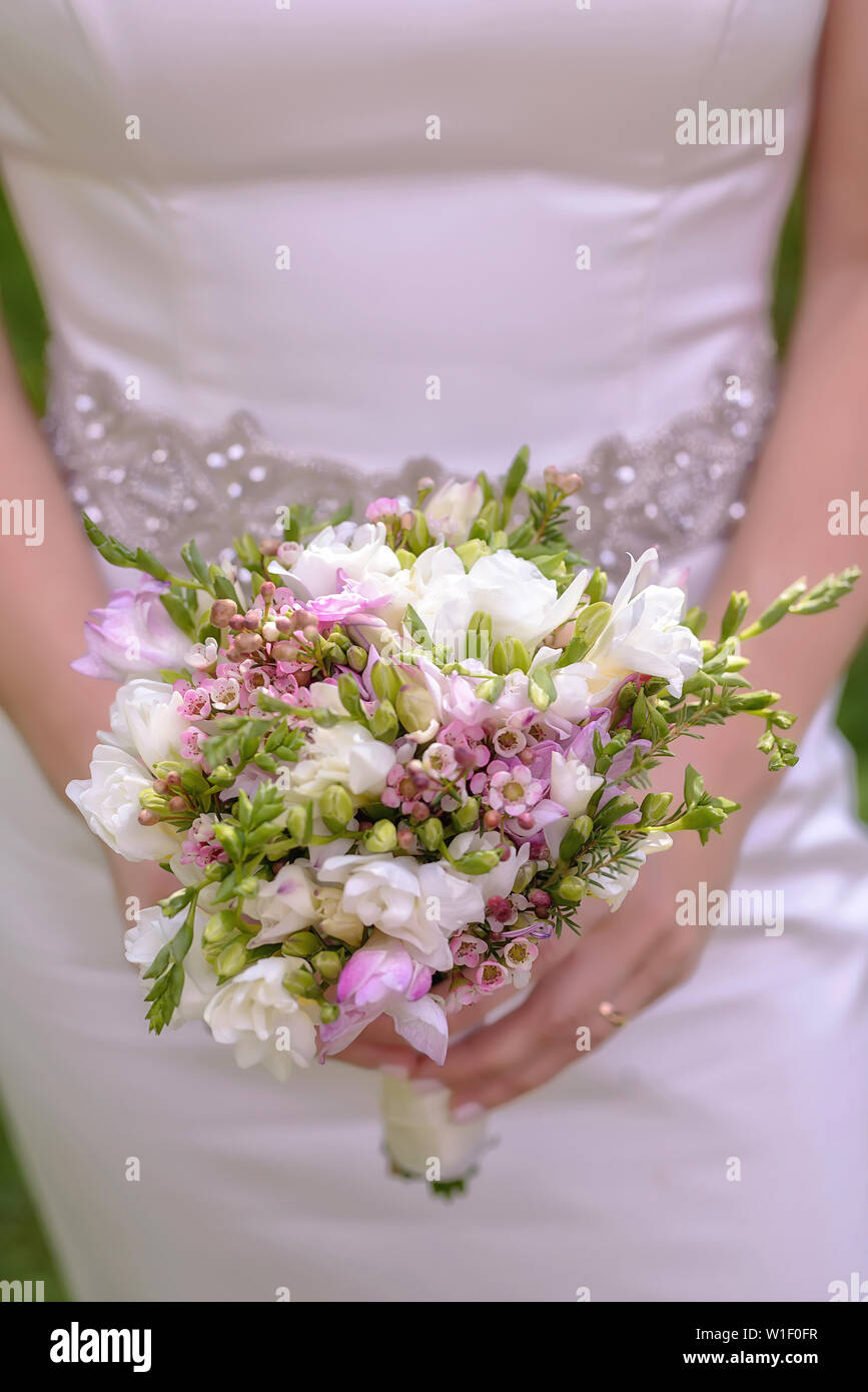 Close-up, vertikale Perspektive der kaukasischen Braut oder Brautjungfer mit einem kleinen schönen Frühlingsblumen posing Blumenstrauß Stockfoto