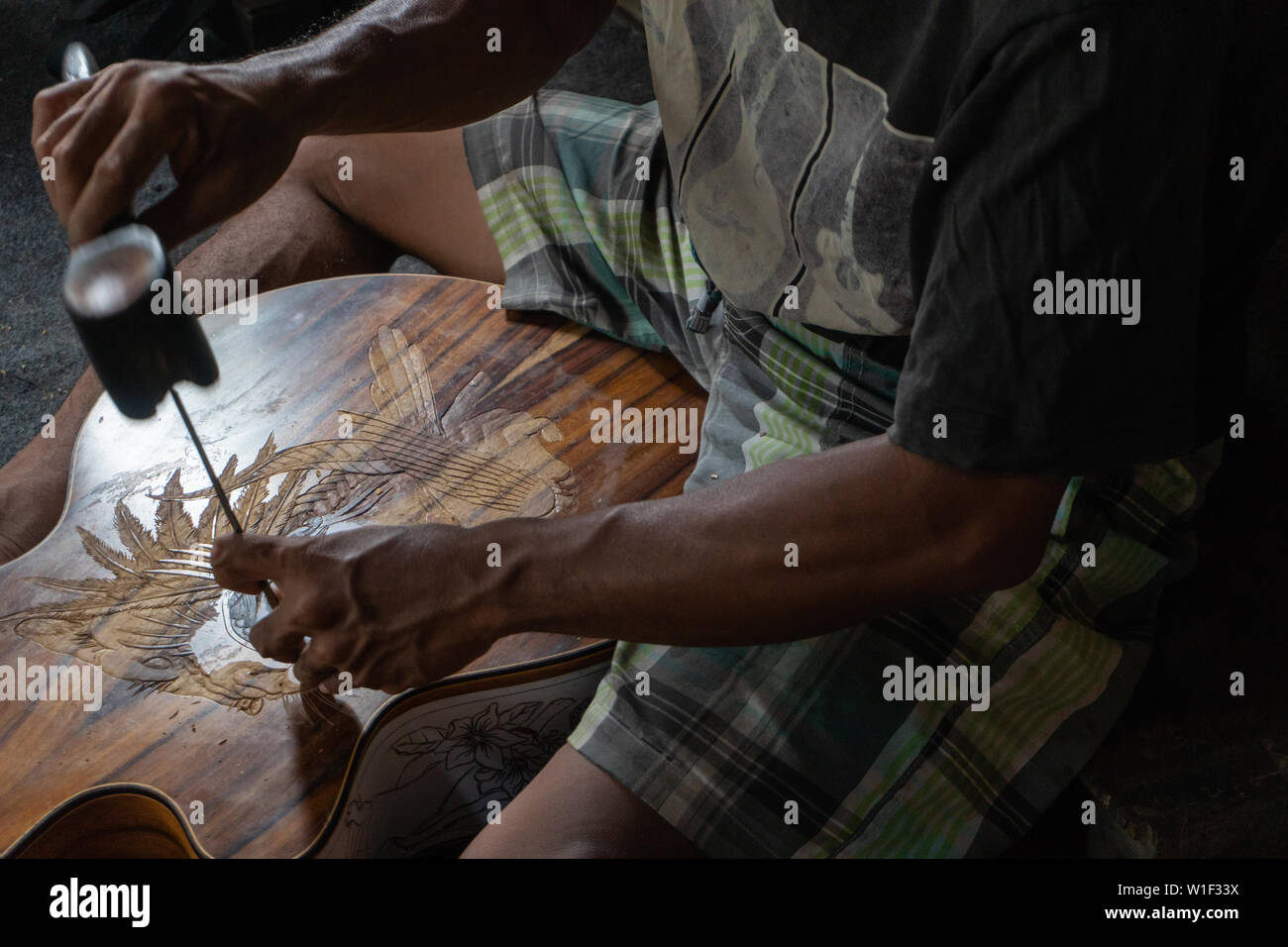 Eine Gitarre Handwerker schnitzen eine klassische Gitarren aus Holz, mit balinesischen Muster, in einem hölzernen Gitarren Workshop an Guwang Dorf, Gianyar, Bali Stockfoto