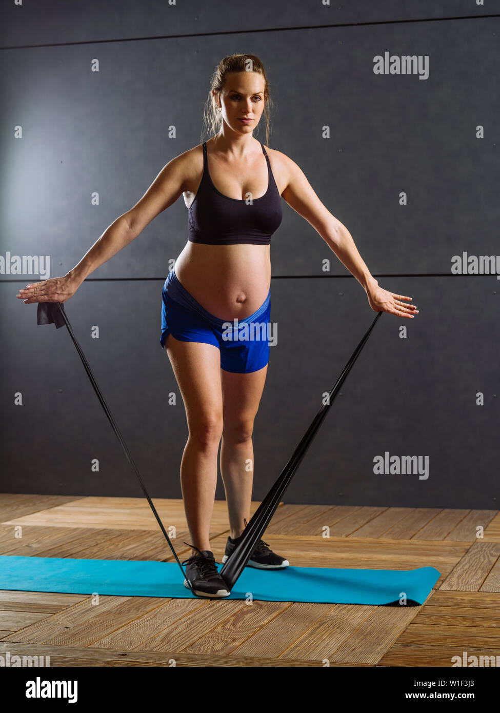 Foto einer schwangeren Frau in den dreißiger Jahren Training mit einem Widerstand Band. Stockfoto