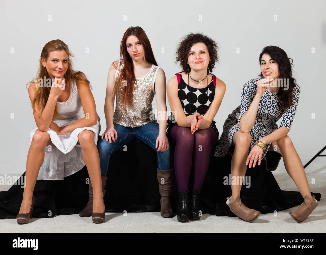Vier schöne Frauen stellen gemeinsam im Studio Stockfoto