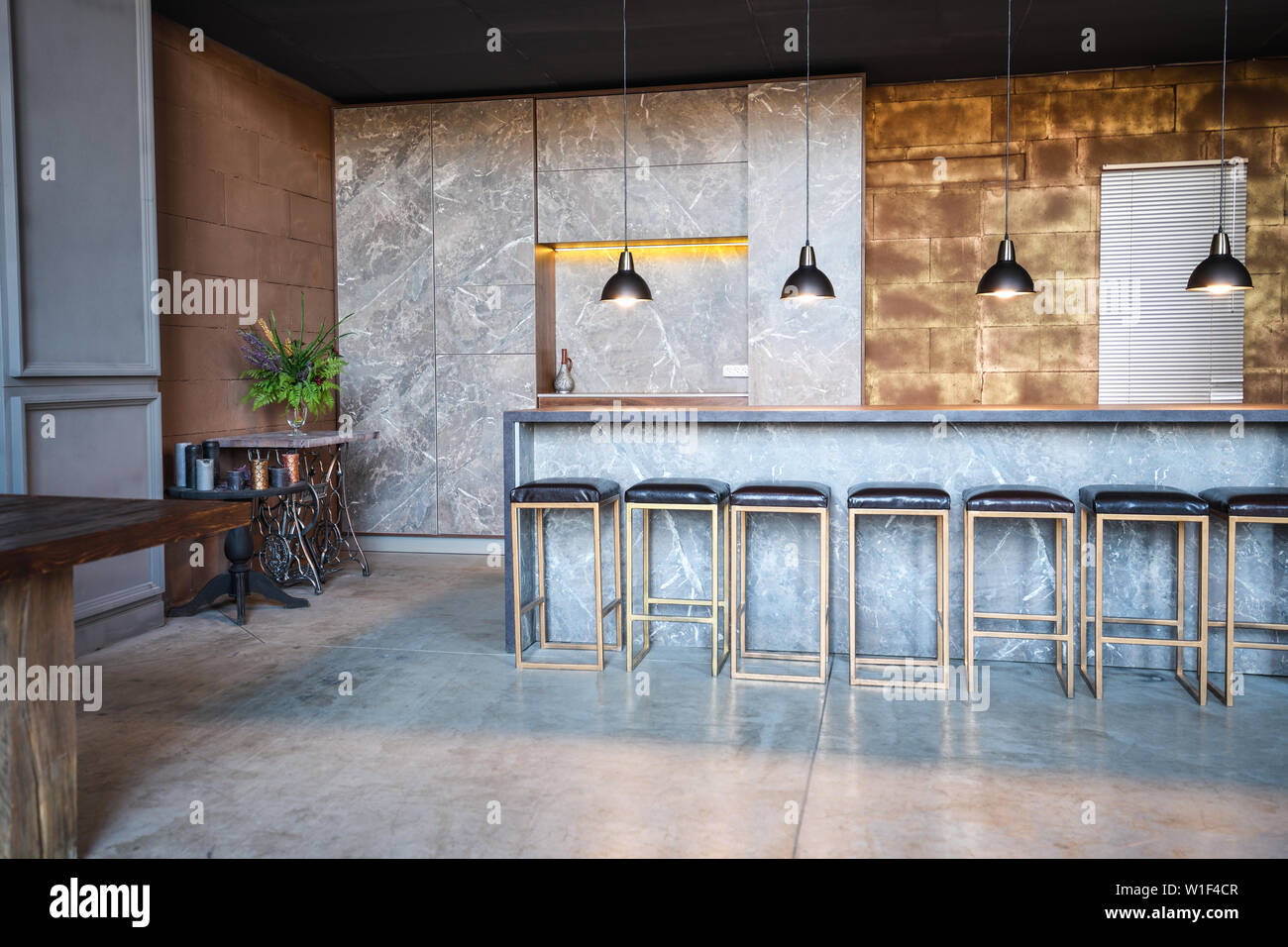 Industrielle Loft Bar Stil. Das Zimmer hat eine Menge Stühle an der Bar, vier überhängenden Lampen, marmortisch Stockfoto
