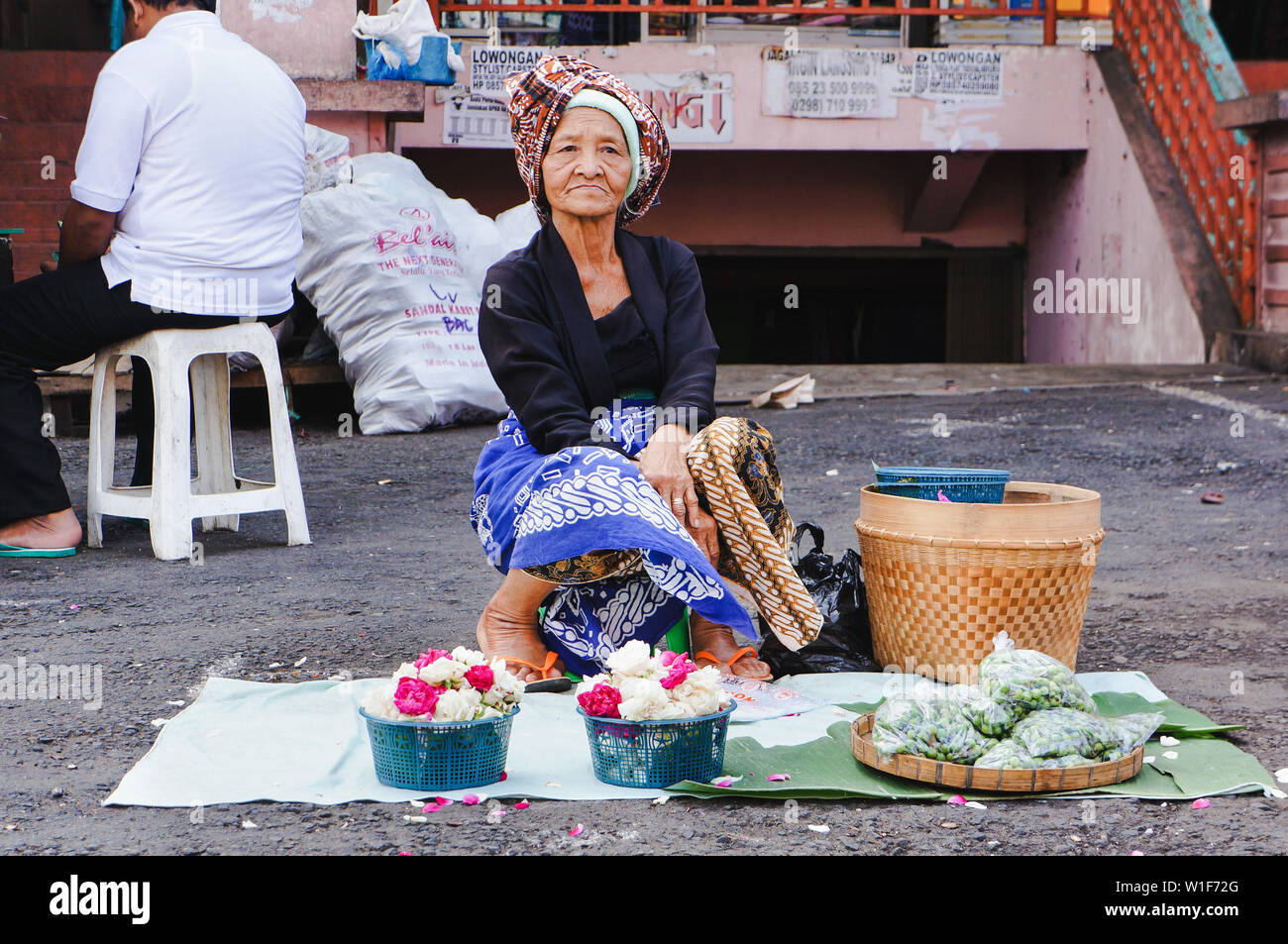 Alte Frau, die Blumen in Salatiga, Indonesien Stockfoto