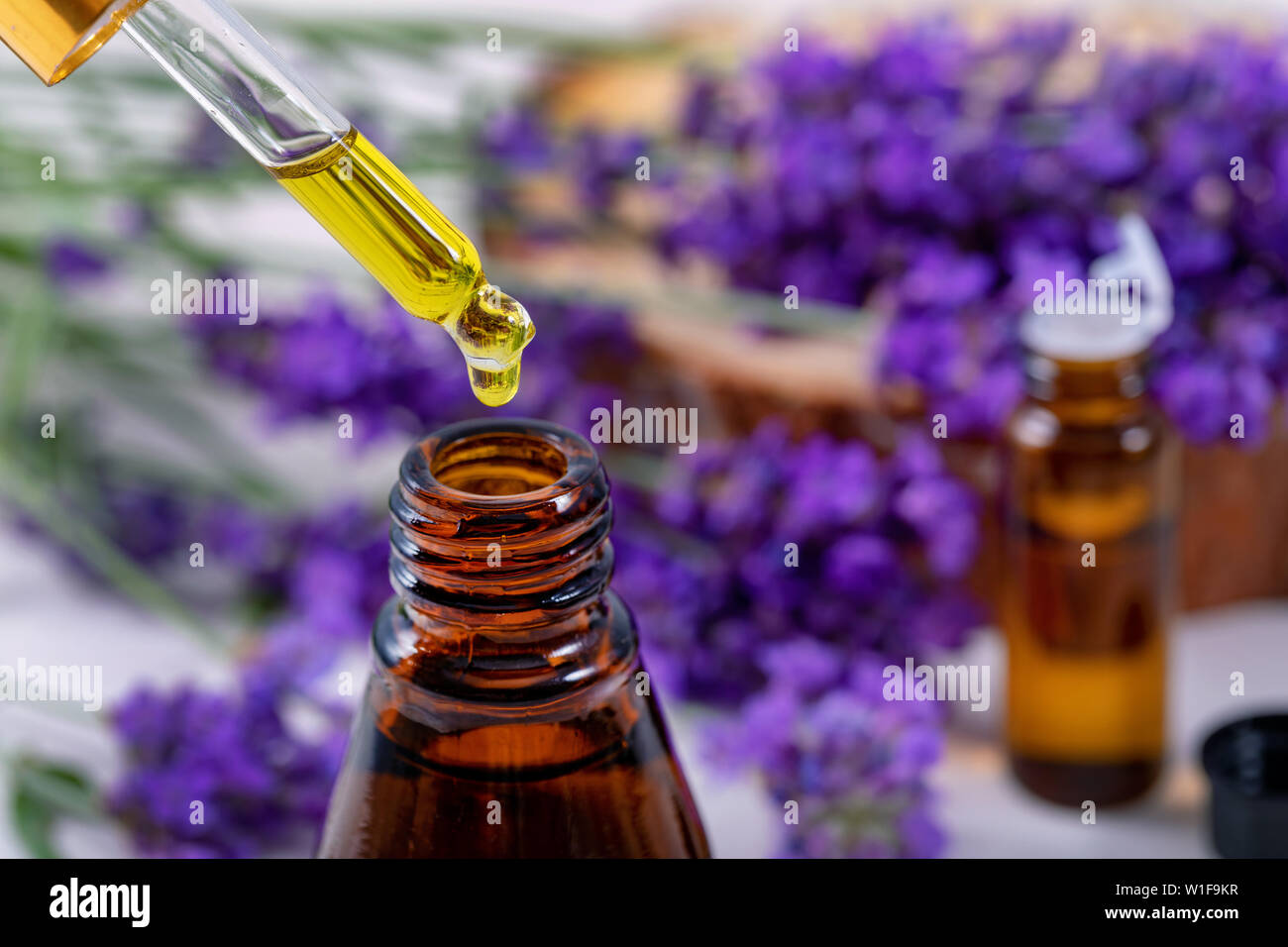 Lavendel ätherisches Öl Tropfen aus der Pipette über die Flasche Stockfoto