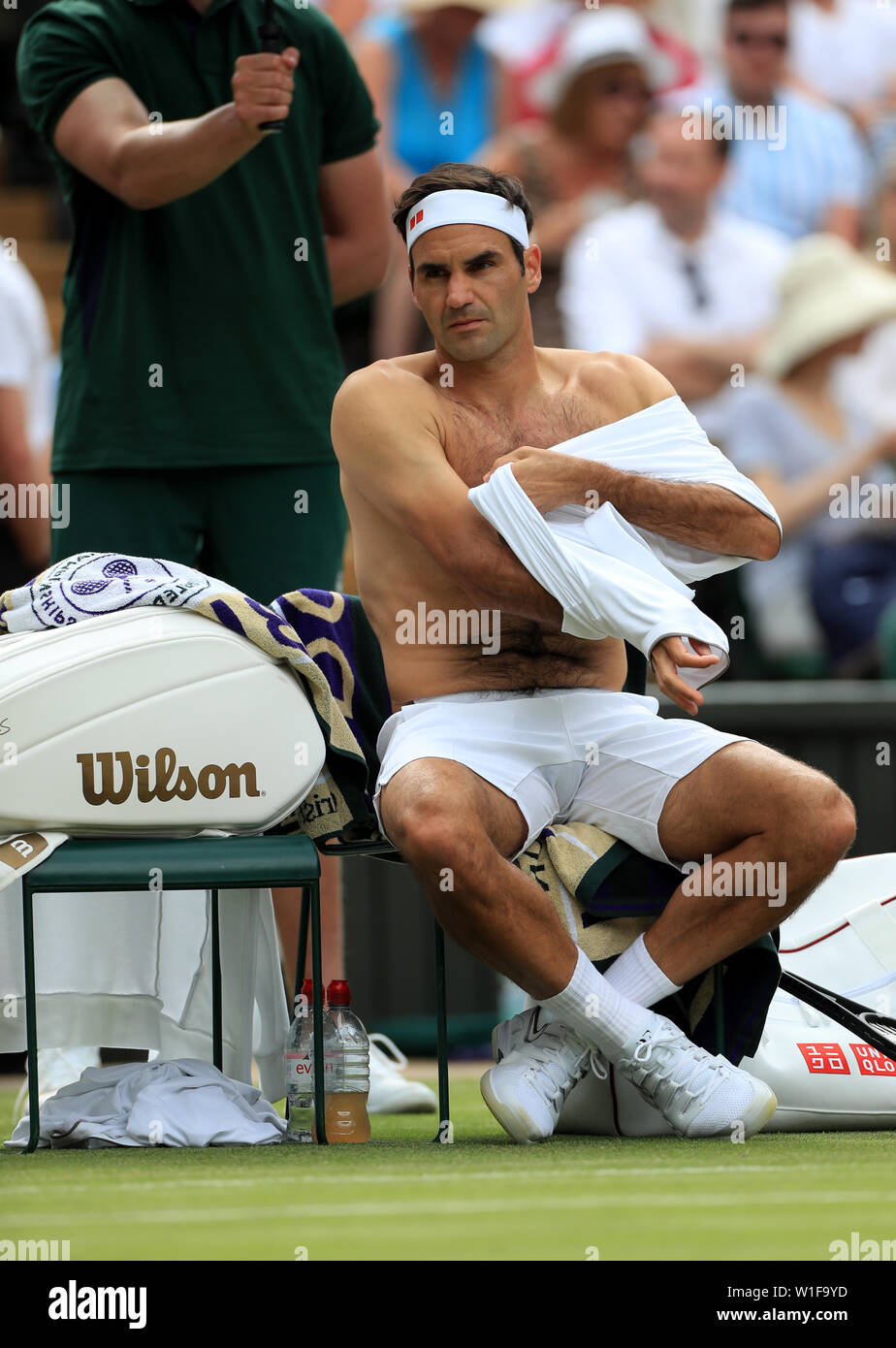 Roger Federer wechselt während einer Spielpause am zweiten Tag der Wimbledon Championships im All England Lawn Tennis and Croquet Club, Wimbledon, das Trikot. Stockfoto