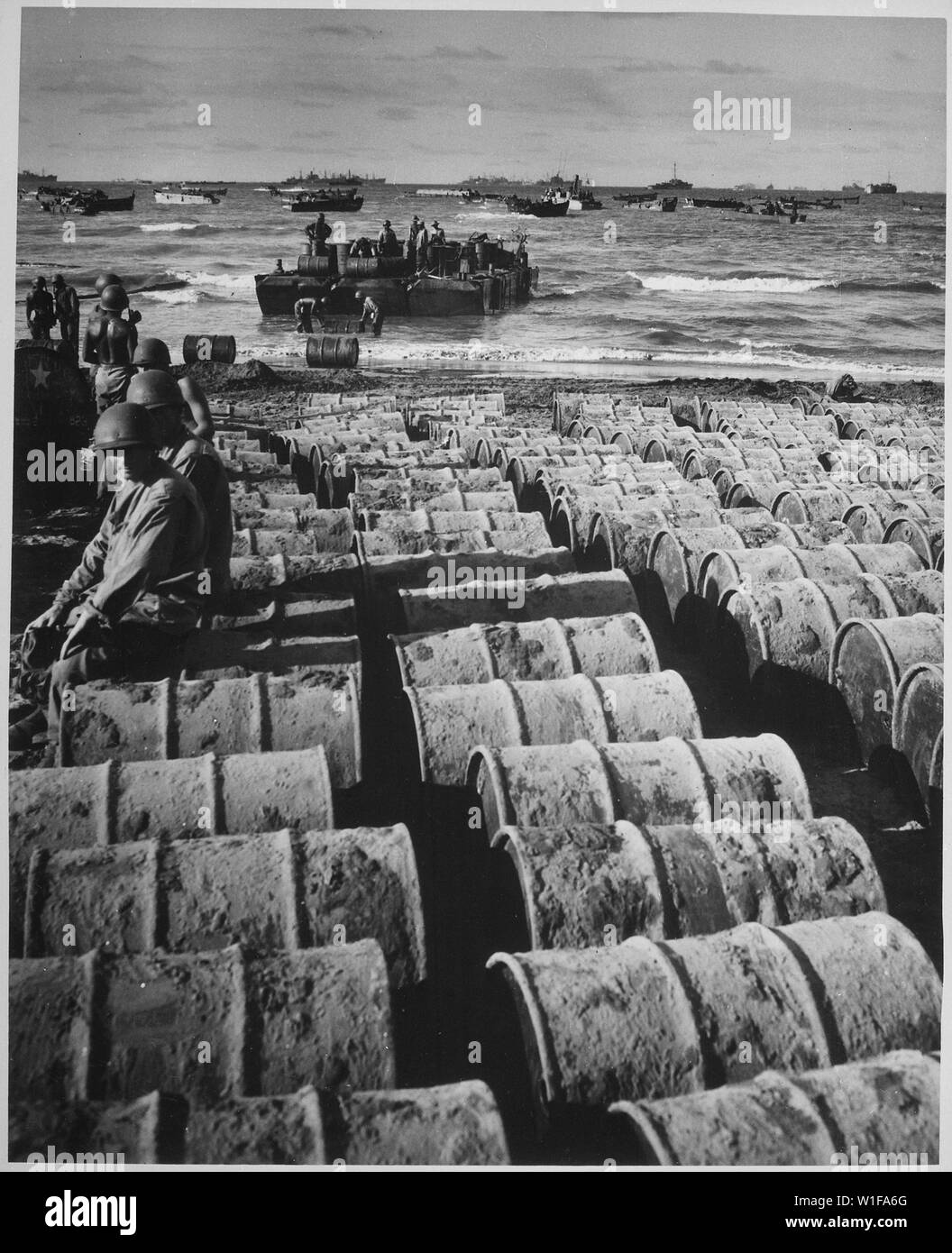 Hunderte von Fässer mit Benzin, Rollen auf dem Sand von Luzon von Coast Guard - Bemannte Landing Craft grafisch erklären, warum der Autofahrer Gas Lebensmittelkarten tragen und warum gelegentlich die Kraftstoffpumpen trocken laufen.; Allgemeine Hinweise: Verwenden Sie Krieg und Konflikt Nummer 857 bei der Bestellung eine Reproduktion oder Anforderung von Informationen zu diesem Bild. Stockfoto