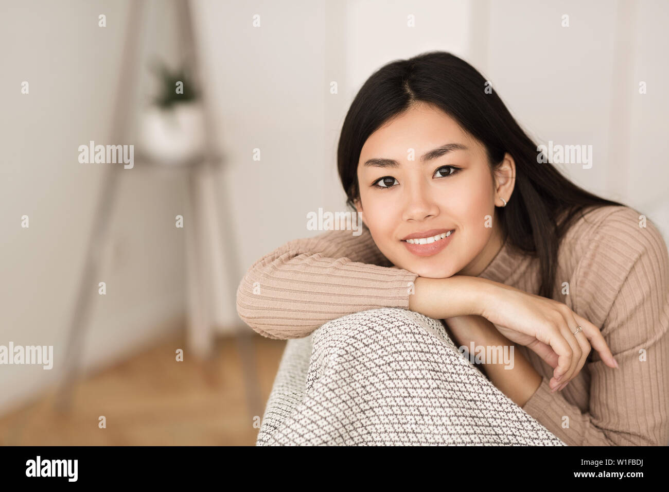 Entspannt asiatischen Mädchen mit Kamera im Wohnzimmer Stockfoto